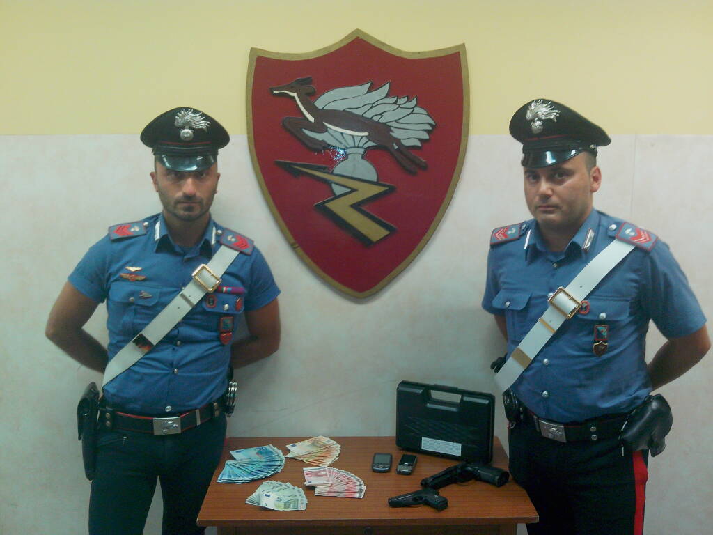 Il denaro e le pistole sequestrati dai Carabinieri